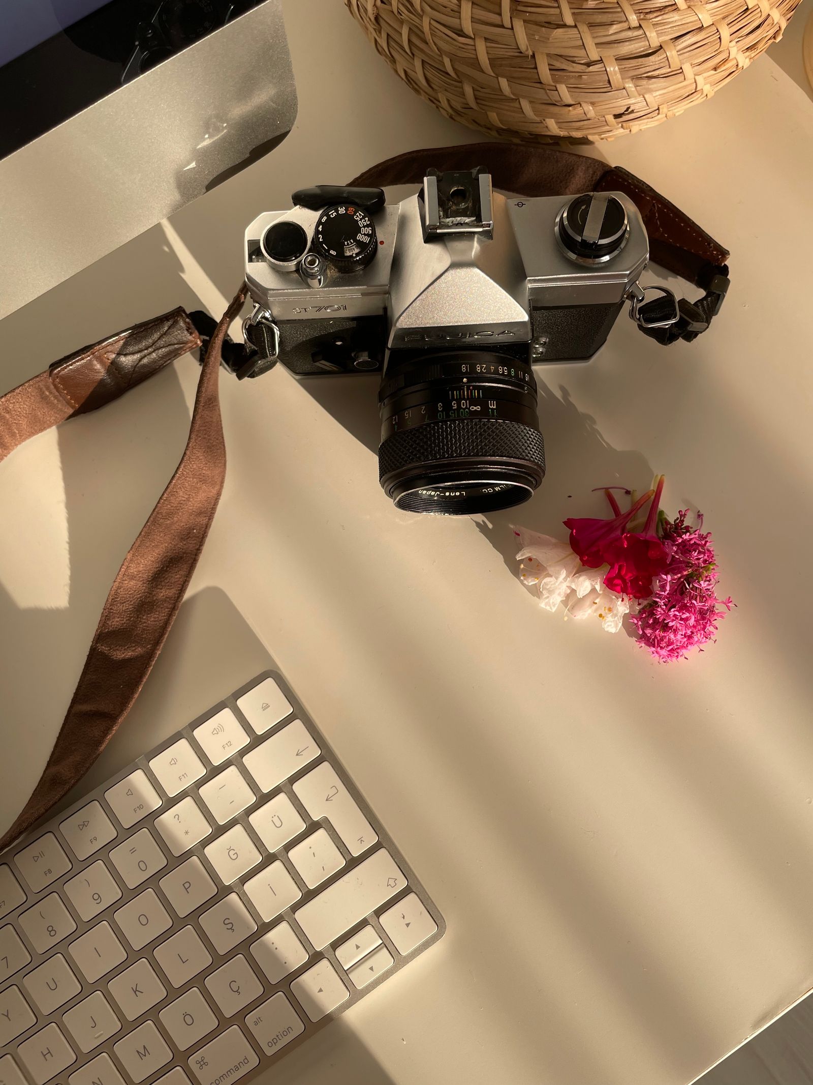 Close-up of a professional camera resting on a clean white surface